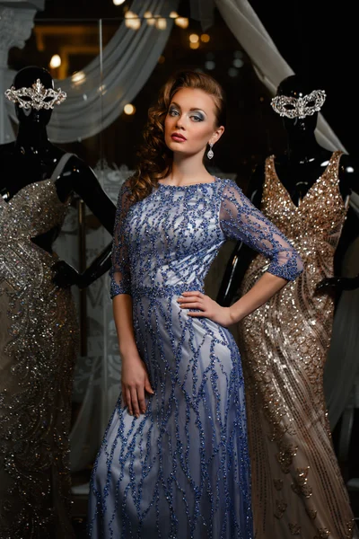 Fashionable woman in blue dress with rhinestones and mannequins — Stock Photo, Image