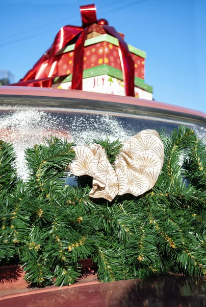 车顶上的新年礼物 前景光明的是一棵带有米黄色大蝴蝶结的圣诞树的枝条 — 图库照片