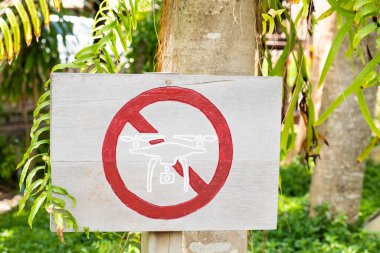 İHA 'nın bu bölgede uçmasına izin verilmediğini bildirmek için ahşaptan yapılmış bir işaret. İHA 'nın uçurulmasına izin verilmeyen ulusal park alanı.