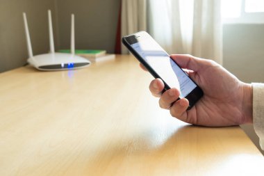 Erkekler internet yönlendiricisinden kablosuz ağa bağlanmak için akıllı telefon kullanırlar. Çevrimiçi birçok uygulama ve hizmetlere erişmek için yüksek hızlı internet ağı teknolojisini genişlet.