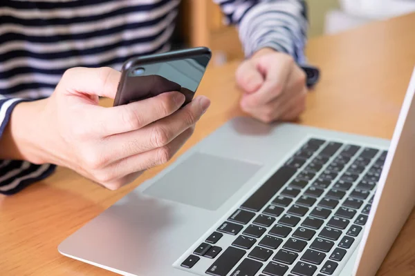 Män Hand Med Mobiltelefon Framför Datorn Laptop Träbord Hemma Höghastighetsinternet Stockbild