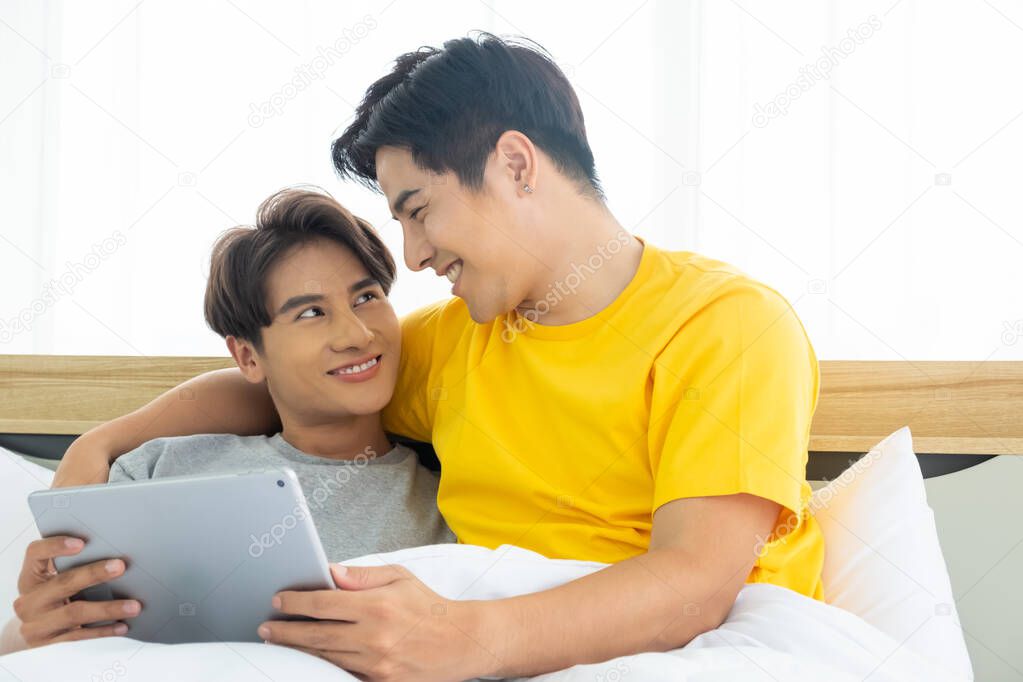 Asian gay homosexual couple hug and embracing on the bed.  Gender equality and right concept, playful and romantic moment.