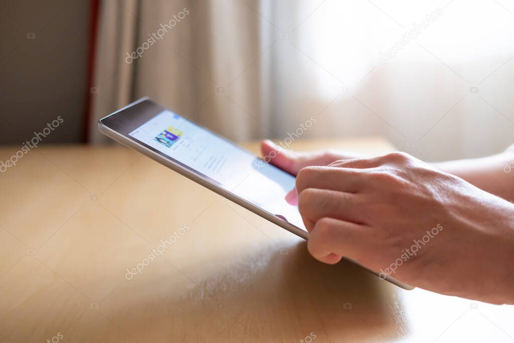 Selective focus at the edge of tablet. Men hand pressing the screen of smartphone tablet while search or browsing internet for reading news or information. Communication technology with copy space.