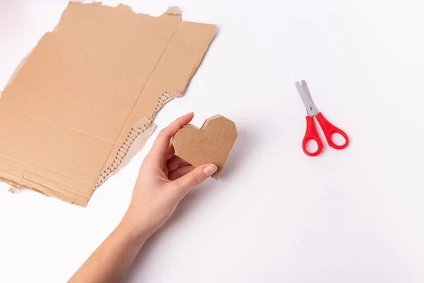 Hands make a valentine craft, cardboard heart — Stock Photo, Image