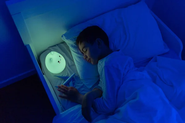Jongen slapen met led-nachtlamp, zachte focus — Stockfoto