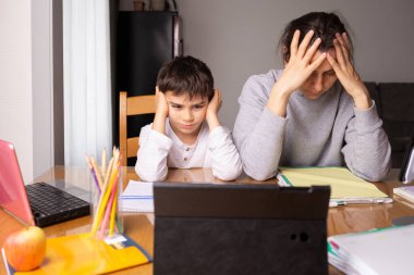 Anne çocuğuna evde ders veriyor, ev ödevi yapıyor.