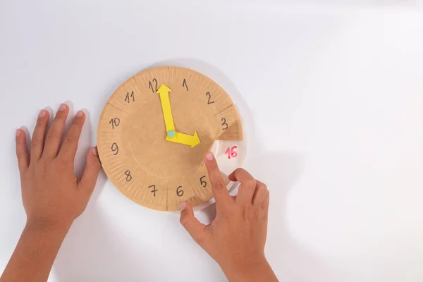 Дети учатся различать время на часы ручной работы игрушки — стоковое фото