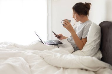 Cep telefonu bağımlısı kadın yatakta uyanık.