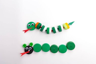 Çocuklar için DIY yaz sanatı, nasıl yılan yapılır, plastik şişe kapağı, ev yapımı el işi, beyaz arka plan