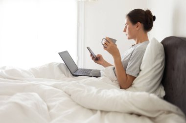 Cep telefonu bağımlısı kadın yatakta uyanık.