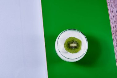 Yeşil ve beyaz arka planda kivi, dikdörtgen, yatay ve simetri içeren yoğurt kabı