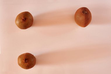 Beyaz arka planda üç kivi, simetri, temiz arkaplan, gölgeler