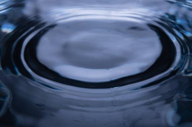 309.00 'da su yüzeyine yakın çekim merkezi darbeden kaynaklanan eş merkezli dalgalanmalar gösteriyor. Yansımalar ve ışıklandırma pürüzsüz bir doku ve derinlik yaratır. Soyut görsel vurgular akışkan hareket ve dalga davranışını vurgular.