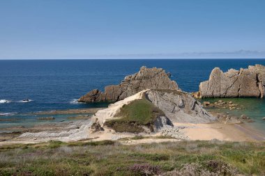 Güneşli bir yaz gününde, Liencres Cantabria 'da kırık bir sahil. Boş kumsal, alçak gelgit, temiz gökyüzü, hava manzarası