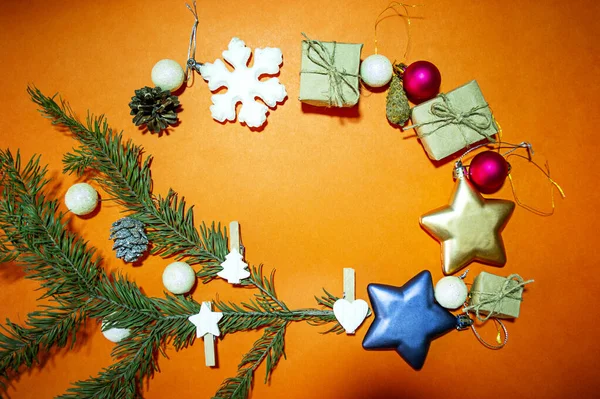 Quadro feito de ramo de abeto e decorações de Natal em fundo laranja, espaço de cópia, foco seletivo — Fotografia de Stock