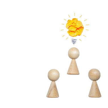 Üç tahta figür ve beyaz arka planda izole edilmiş bir ampul taklidi, bir fikrin doğuşu kavramı, beyin fırtınası. Boşluğu kopyala.