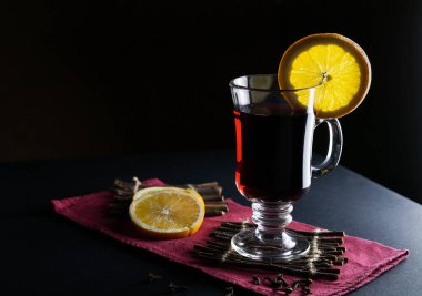 Sıcak sıcak sıcak şarap, uzun cam bardakta, arka planda turuncu pipetlerle fotokopi alanı olan.