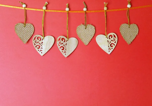 Wooden hearts on a string red background, copy space. Love concept. . High quality photo