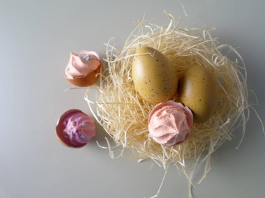 Yuvadaki kuş yumurtaları ve yumurta kabuklarındaki pembe kekler Paskalya baharı natürmort yaşam, seçici odak, kopyalama alanı. Yüksek kalite fotoğraf