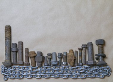 Metal cıvatalar ve fındıklar kahverengi arka plandaki metal bir zincirin temelinde, fotokopi alanı, modern şehir konsepti. Yüksek kalite fotoğraf