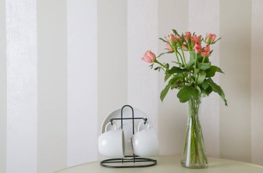 Masada bir buket gül ve bir çift fincan var. Yüksek kalite fotoğraf