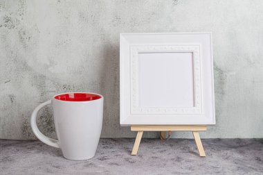 Beyaz kupa ve fotoğraf çerçeveli minimalist iç mimari