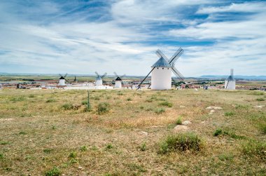 CAMPO DE CRIPTANA, İspanya - 22 Mayıs 2021: İspanya 'nın ünlü Don Kişot Yolu üzerindeki Campo de Criptana kentindeki tipik yel değirmenlerini ziyaret eden turistler