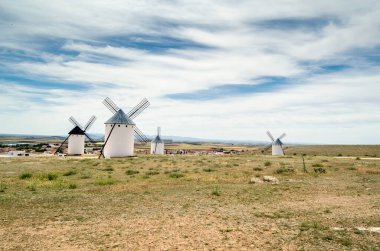 CAMPO DE CRIPTANA, İspanya - 22 Mayıs 2021: İspanya 'nın ünlü Don Kişot Yolu üzerindeki Campo de Criptana kentindeki tipik yel değirmenlerini ziyaret eden turistler