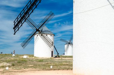CAMPO DE CRIPTANA, İspanya - 22 Mayıs 2021: İspanya 'nın ünlü Don Kişot Yolu üzerindeki Campo de Criptana kentindeki tipik yel değirmenlerini ziyaret eden turistler