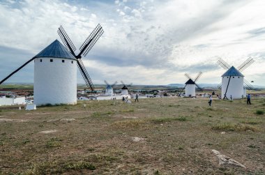 CAMPO DE CRIPTANA, İspanya - 22 Mayıs 2021: İspanya 'nın ünlü Don Kişot Yolu üzerindeki Campo de Criptana kentindeki tipik yel değirmenlerini ziyaret eden turistler