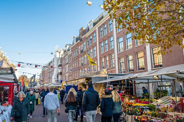 AMSTERDAM, NETHERLANDS - 17 Kasım 2018: İnsanlar şehrin De Pijp bölgesindeki Albert Cuypstraat 'taki Albert Cuyp Pazarı' nı, bir sokak pazarı ve turistik eğlence merkezini ziyaret ediyorlar
