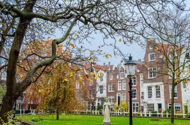 AMSTERDAM, NETHERLANDS - 16 Kasım 2018: Begijnhof 'taki Mimarlık (Beguinage), Amsterdam' da Orta Çağ 'da kurulan bir iç mahkeme, çoğunlukla özel konutlar olmak üzere tarihsel yapılardan oluşan bir grup..