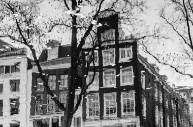 Hollanda, Amsterdam 'daki kanal boyunca uzanan binaların yansıması. Siyah ve beyaz resim