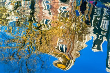 Hollanda, Amsterdam 'daki kanal boyunca uzanan renkli binaların canlı yansıması