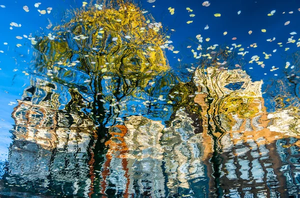 Hollanda, Amsterdam 'daki kanal boyunca uzanan renkli binaların canlı yansıması