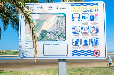 MOGRO, İSPAN - 5 Temmuz 2021: Plajda enfeksiyonları önleyecek tedbirleri gösteren CUID-19 bilgi paneli