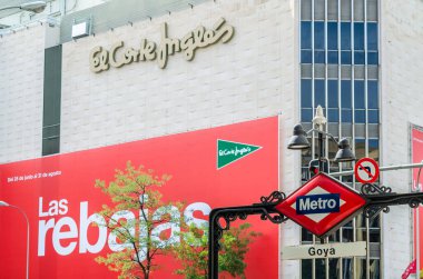 MADRID, SPAIN - 23 Temmuz 2021: Goya metro istasyonunda arka planda El Corte Ingles mağazasının ön cephesi olan Madrid Metro tabelası