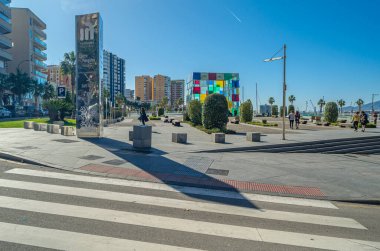 MALAGA, İspanya - 27 Ocak 2020: Arka planda Pompidou Malaga Merkezi ile İspanya 'nın Malaga kentindeki gezinti alanı boyunca modern mağazaları ve restoranları olan 