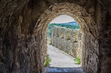 BUITRAGO DEL LOZOYA, İspanya - 3 Temmuz 2016: Mimari ayrıntı, Buitrago del Lozoya Kalesi 'nde kemer ve tünel ile surlarda yürüyüş, İspanya Topluluğu, Gotik-Mudejar tarzında 15. yüzyılda inşa edildi.