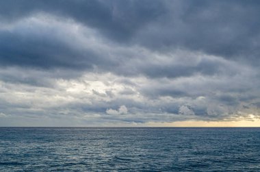 Gün batımında deniz manzarası, bulutlu gökyüzü