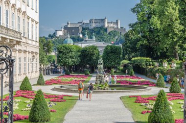SALZBURG, AUSTRIA - 5 Temmuz 2015: Salzburg, Avusturya 'da geometrik çiçekli resmi bir barok tarzı halk bahçesi olan Mirabell Sarayı ve Mirabell Bahçeleri' nde gezinen insanlar
