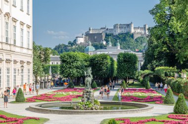 SALZBURG, AUSTRIA - 5 Temmuz 2015: Salzburg, Avusturya 'da geometrik çiçekli resmi bir barok tarzı halk bahçesi olan Mirabell Sarayı ve Mirabell Bahçeleri' nde gezinen insanlar