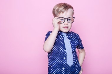 Portre küçük bir çocuk komik gözlük gülümseyen ve kravat. Okul. Okul öncesi. Moda. Stüdyo portre pembe bir arka plan üzerinde