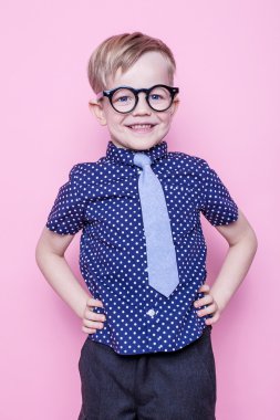 Şık çocuk gömlek ve gözlük kocaman bir gülümseme ile. Okul. Okul öncesi. Moda. Stüdyo portre pembe bir arka plan üzerinde