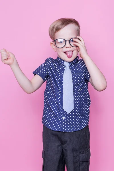 Lilla bedårande pojke i fluga och glasögon. Skolan. Förskola. Fashion. Studio porträtt över rosa bakgrund — Stockfoto