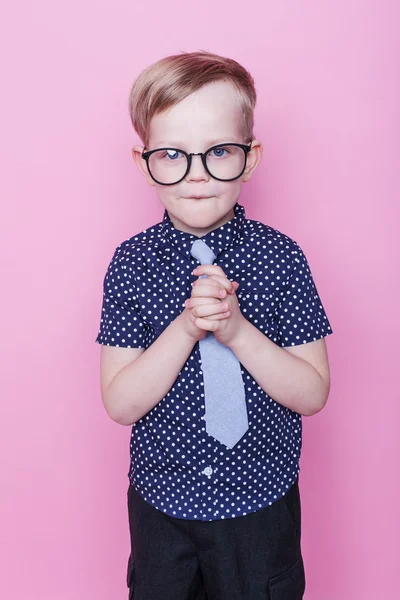 Lilla bedårande pojke i fluga och glasögon. Skolan. Förskola. Fashion. Studio porträtt över rosa bakgrund — Stockfoto