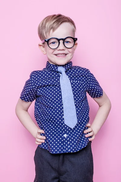 Niño con estilo en camisa y gafas con gran sonrisa. En la escuela. Preescolar. Moda. Estudio retrato sobre fondo rosa —  Fotos de Stock