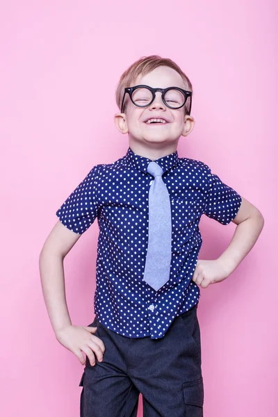 Ragazzino adorabile in cravatta e occhiali. A scuola. All'asilo. Moda. Studio ritratto su sfondo rosa — Foto Stock