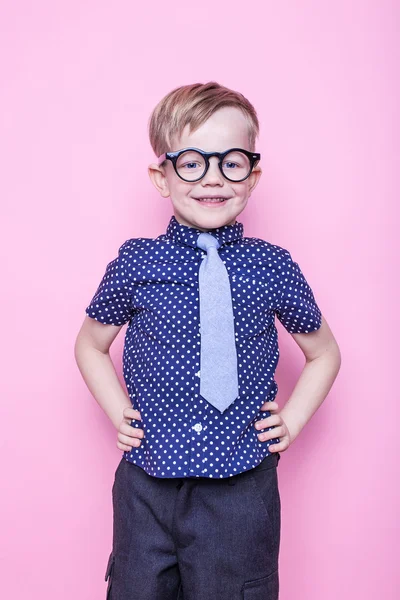 Stylischer Junge in Hemd und Brille mit breitem Lächeln. Schule. Vorschule. Mode. Studioporträt über rosa Hintergrund — Stockfoto