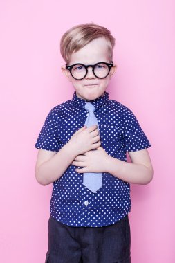 Şık çocuk gömlek ve gözlük kocaman bir gülümseme ile. Okul. Okul öncesi. Moda. Stüdyo portre pembe bir arka plan üzerinde